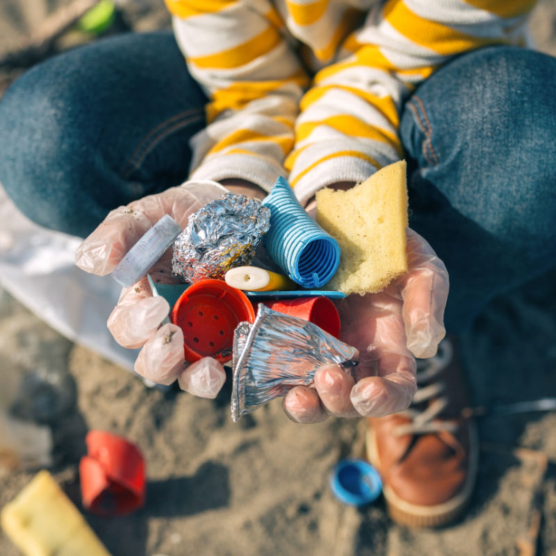 Detail of child hands with garbage collected from the beach